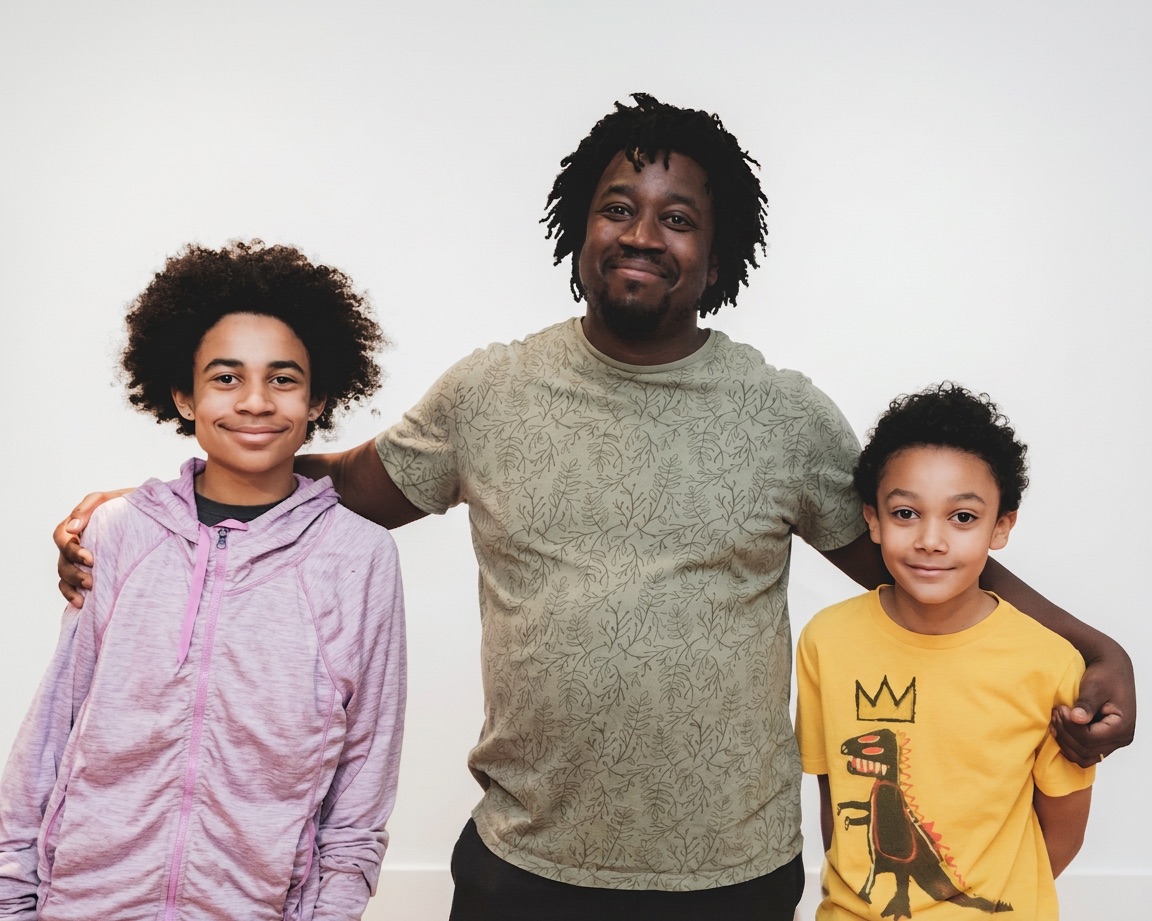 A mentor standing with his arms around two smiling kids