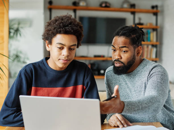 A mentor and teen working together at a laptop